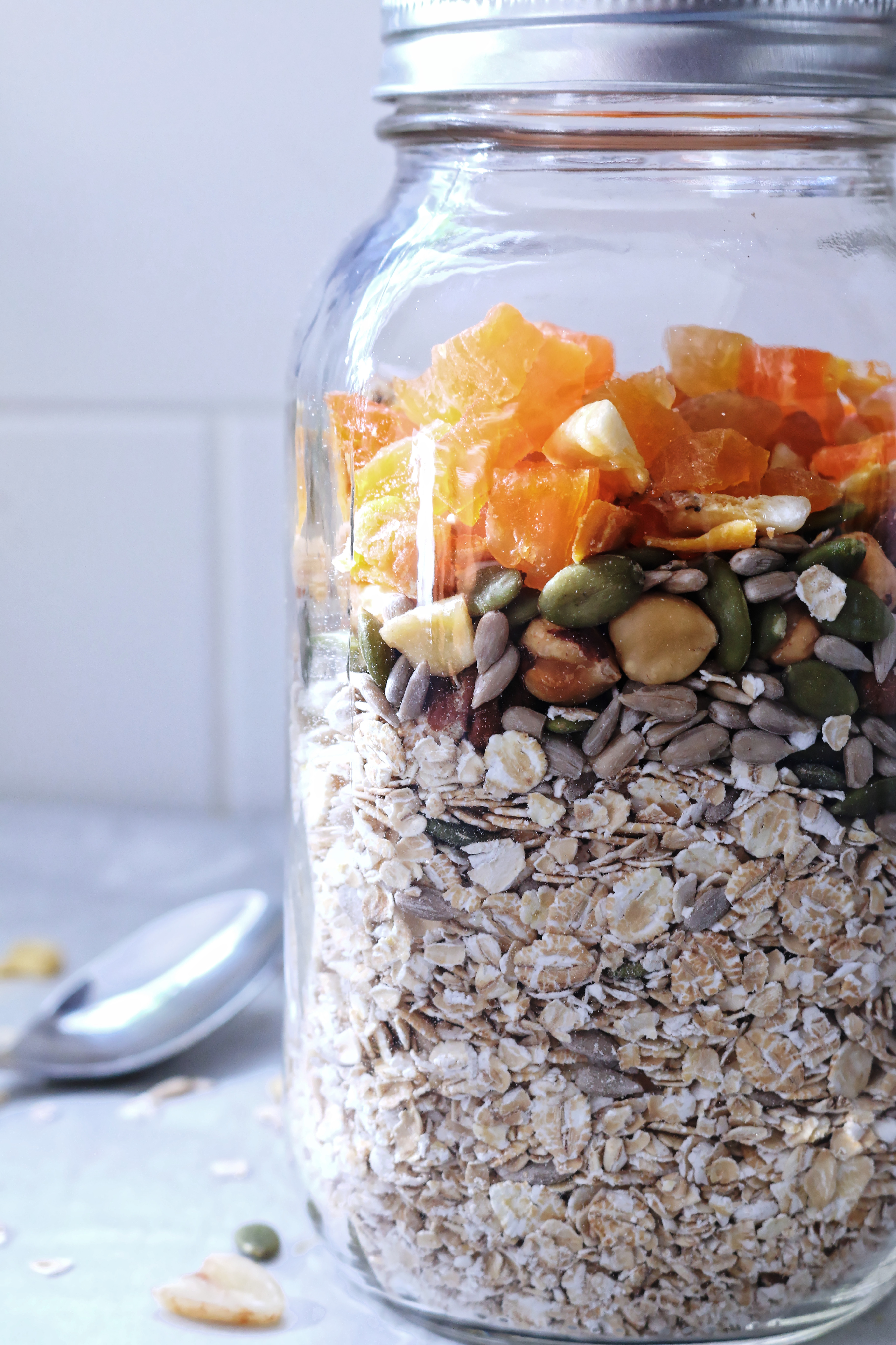 Mason jar muesli with dried fruit, oats and seeds side view