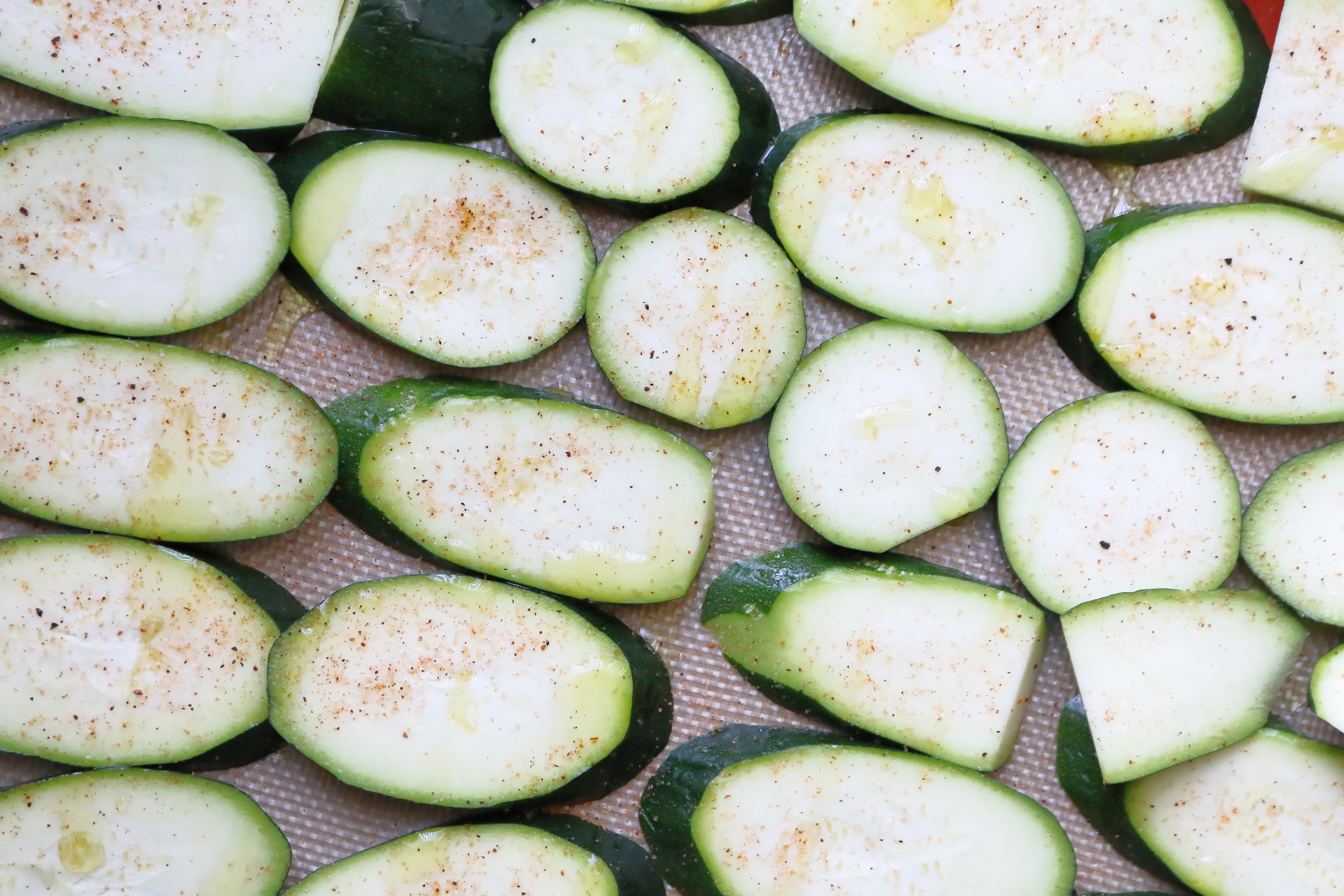 Raw sliced zucchini on baking sheet