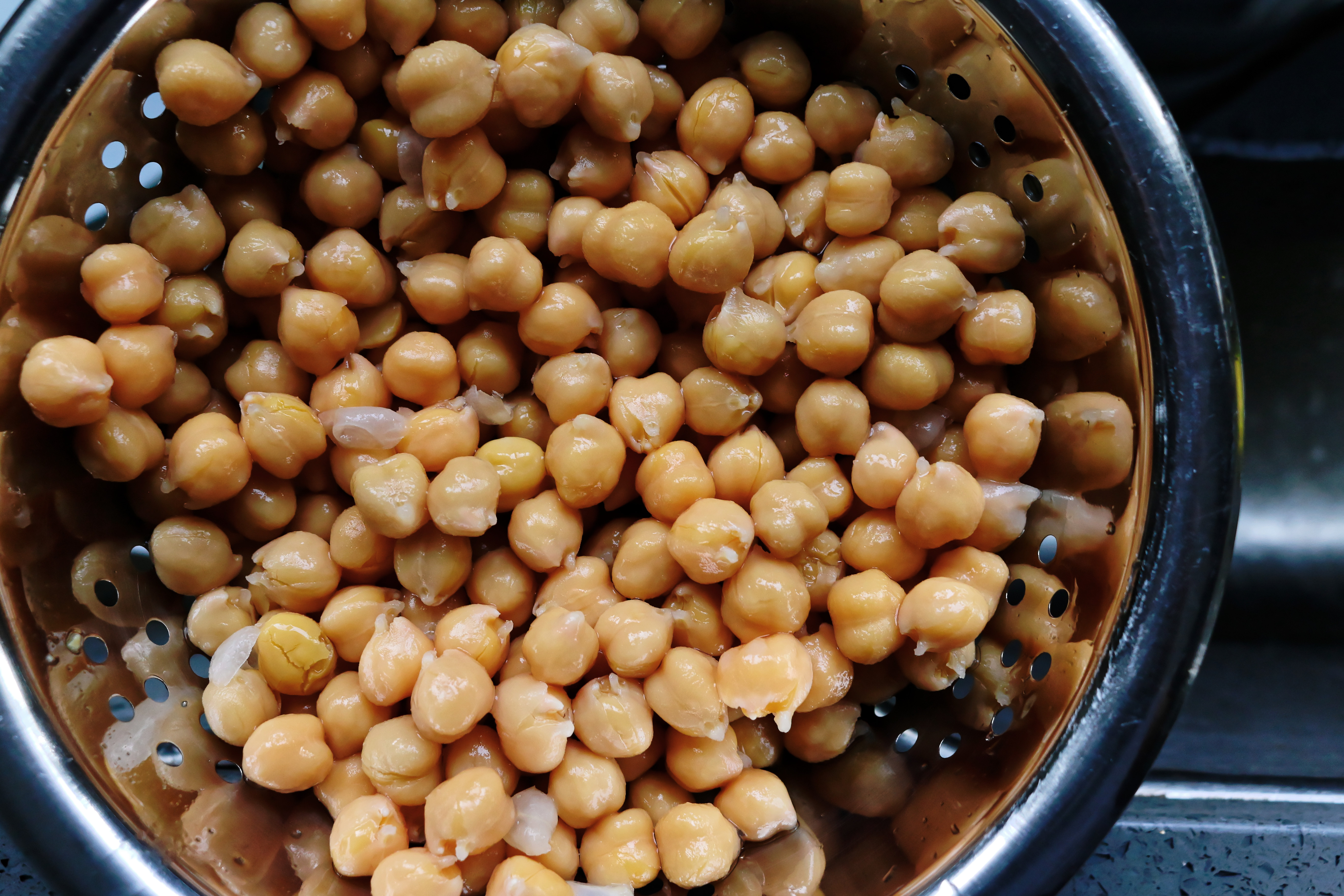 Uncooked canned chickpeas in metal colander drained.jpg